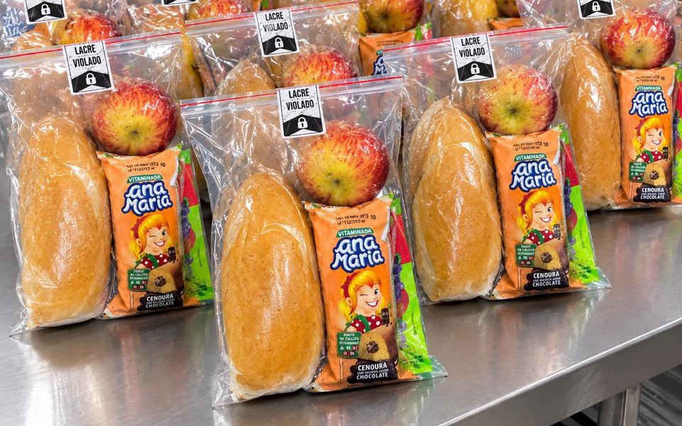 Kits lanche lacrados com pão, maçã e bolinho